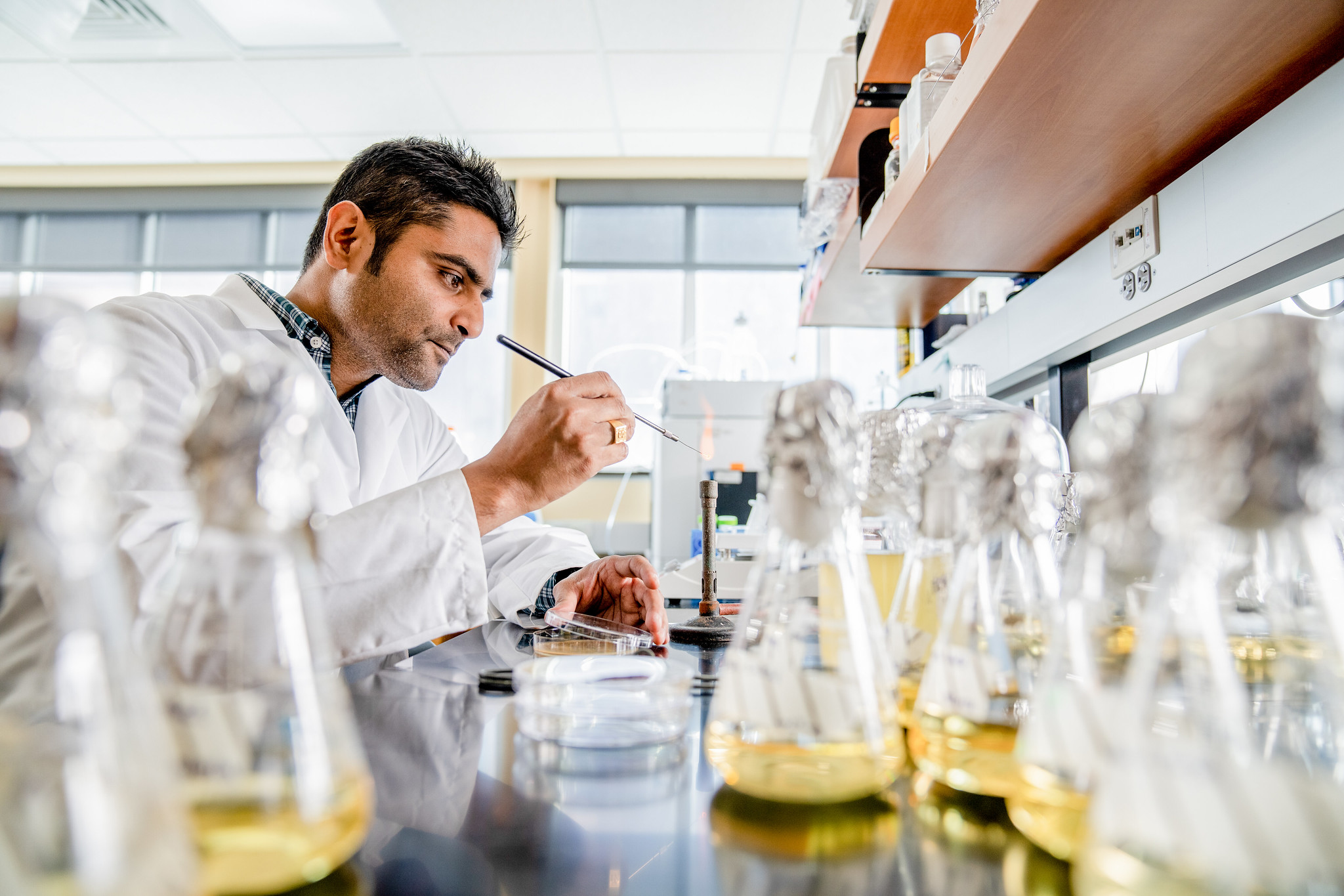 Researcher using lab equipment and glassware during experiment.