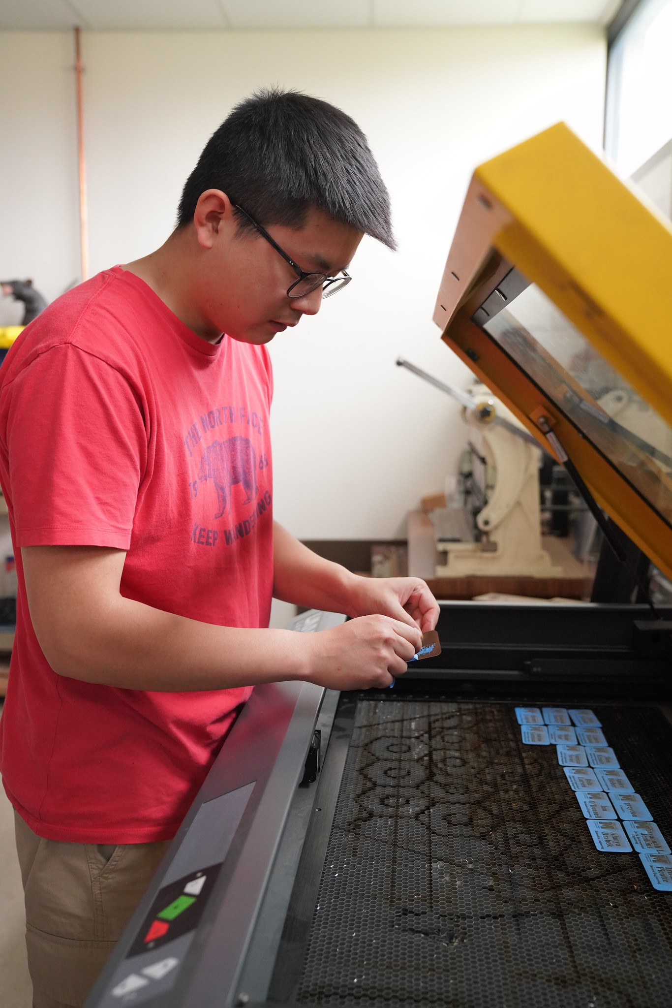 Student using a lasrer cutter in lab.
