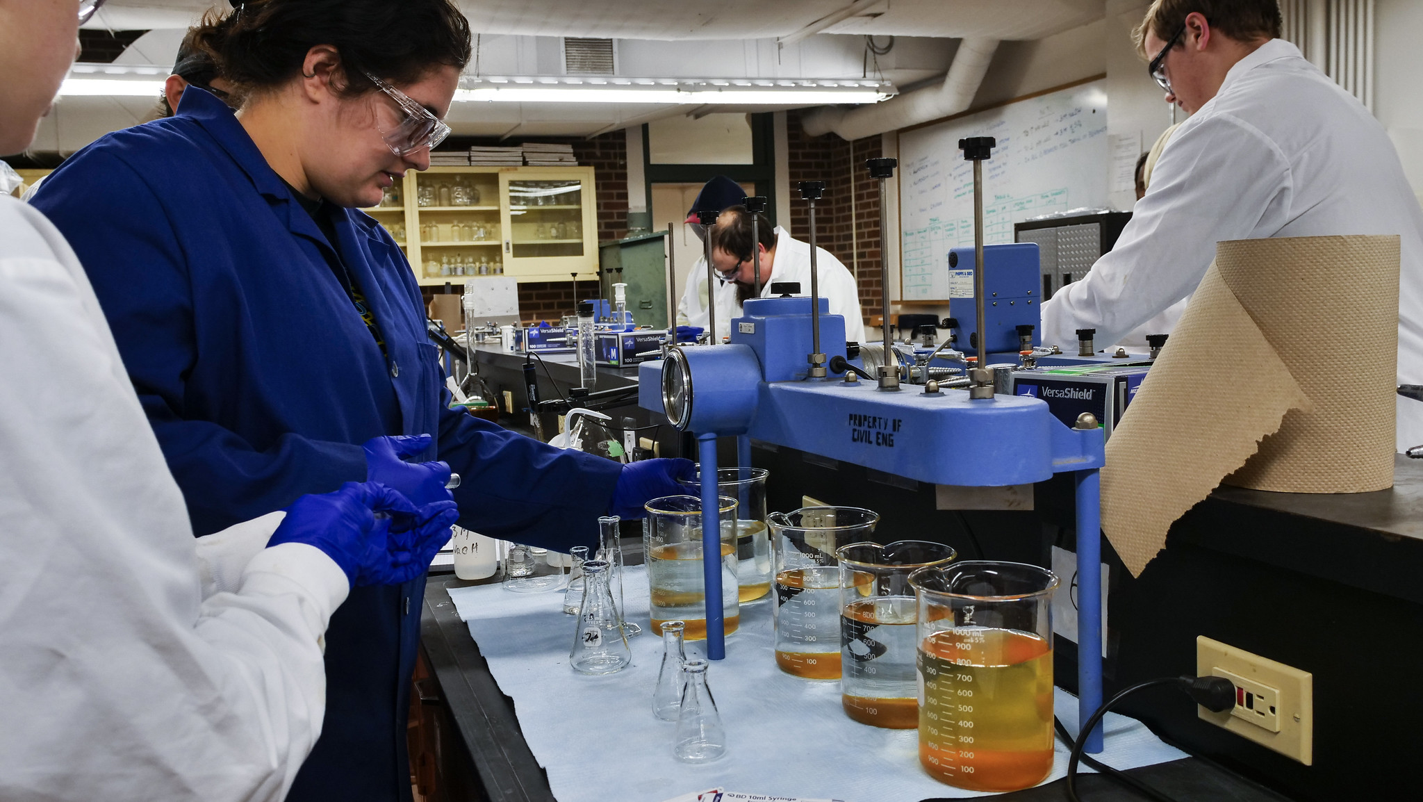 Students analyzing liquid samples in a lab using scientific instruments.