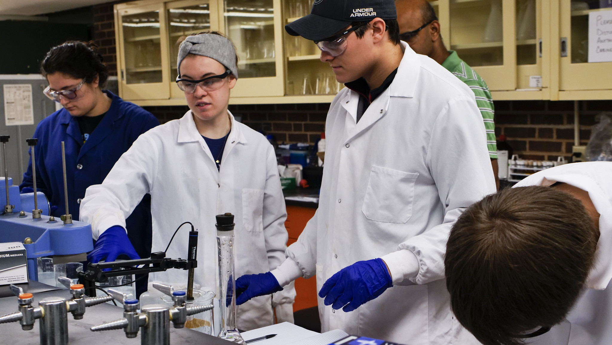 Students working with lab equipments during an experiment.