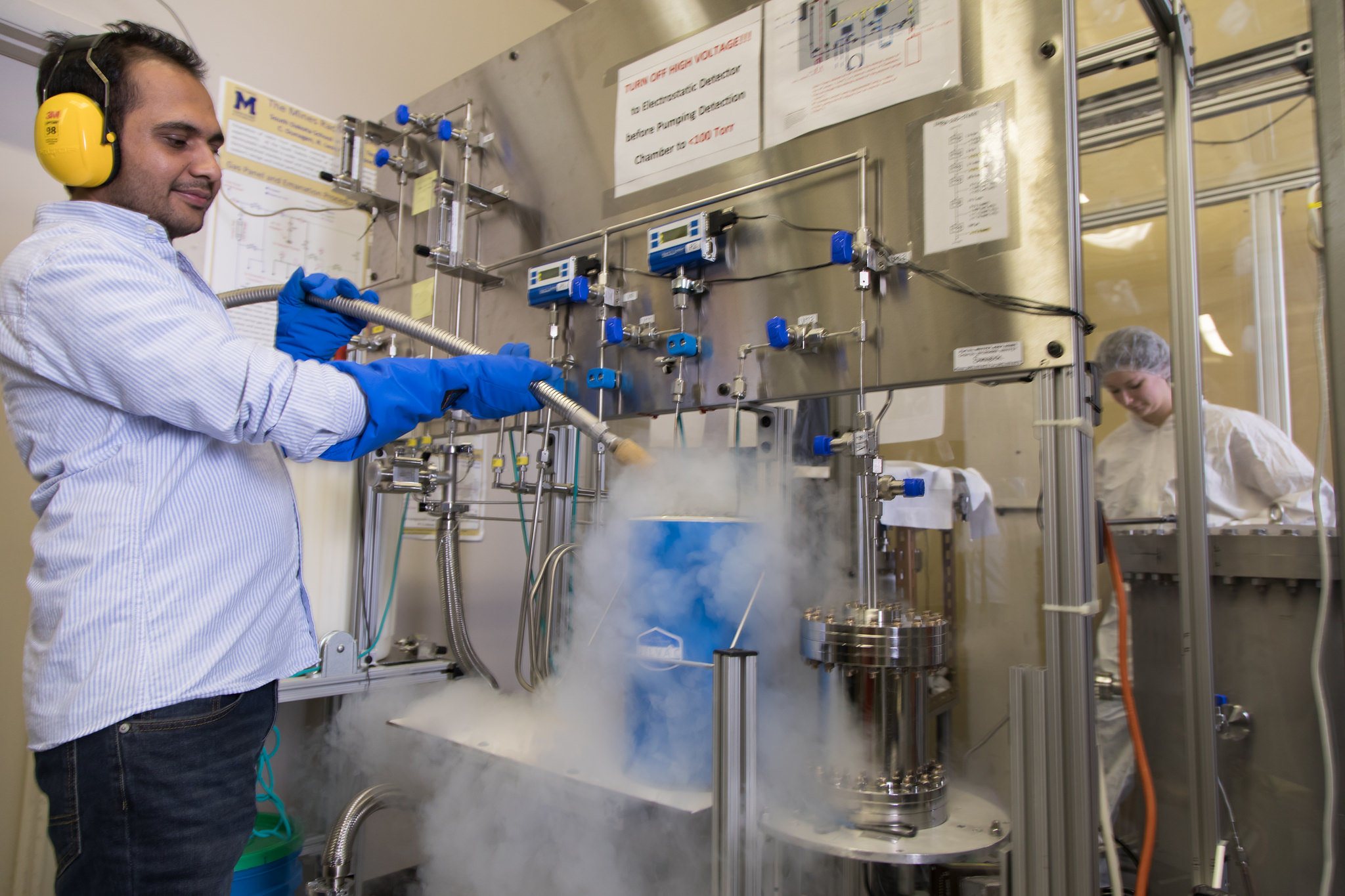 Researcher operating laboratory euipments wearing safety gear.
