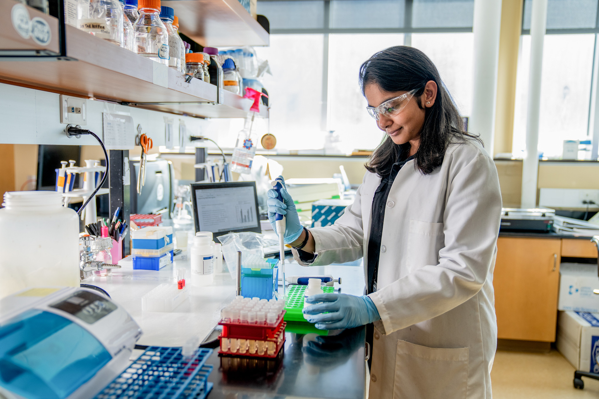 Researcher working with liquid samples in a laboratory setting.
