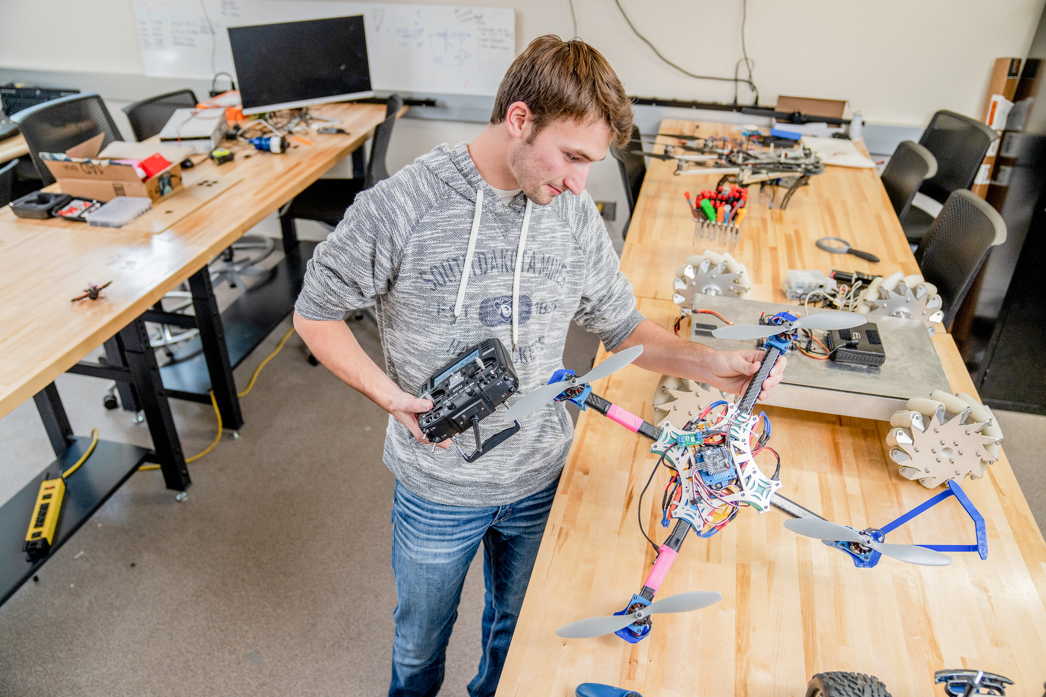 Students working on a drone and robotics equipment in a lab.