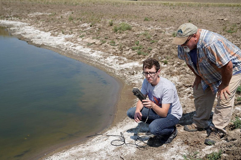Researchers collecting water quality data from a lake.