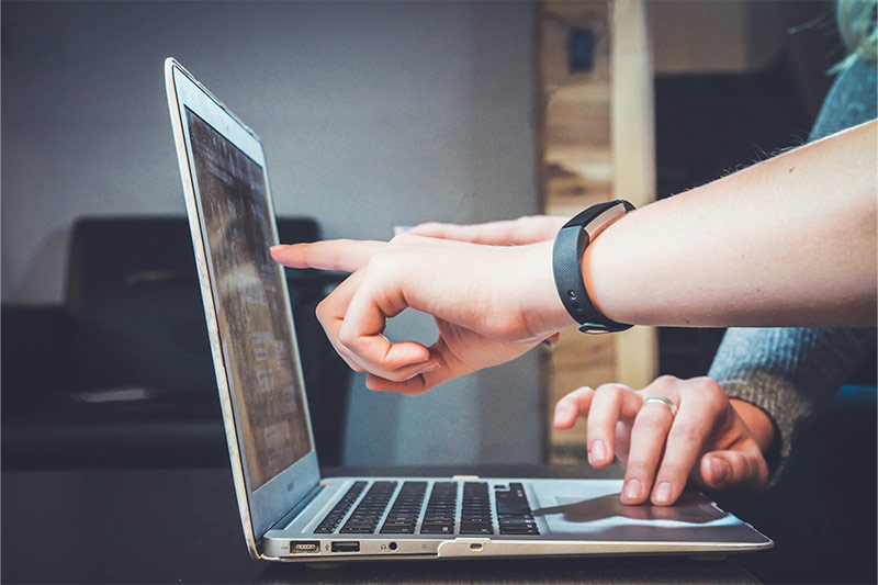 Students pointing at a computer